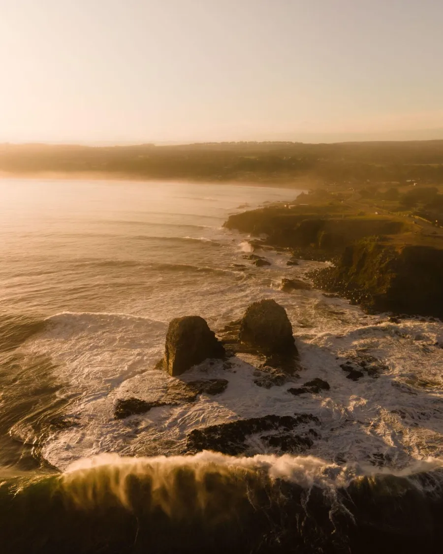Punta de Lobos, Pichilemu: quiscos en primer plano y los morros con el oleaje al atardecer